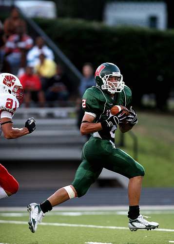 american football man in green 5 American football jersey holding ball football